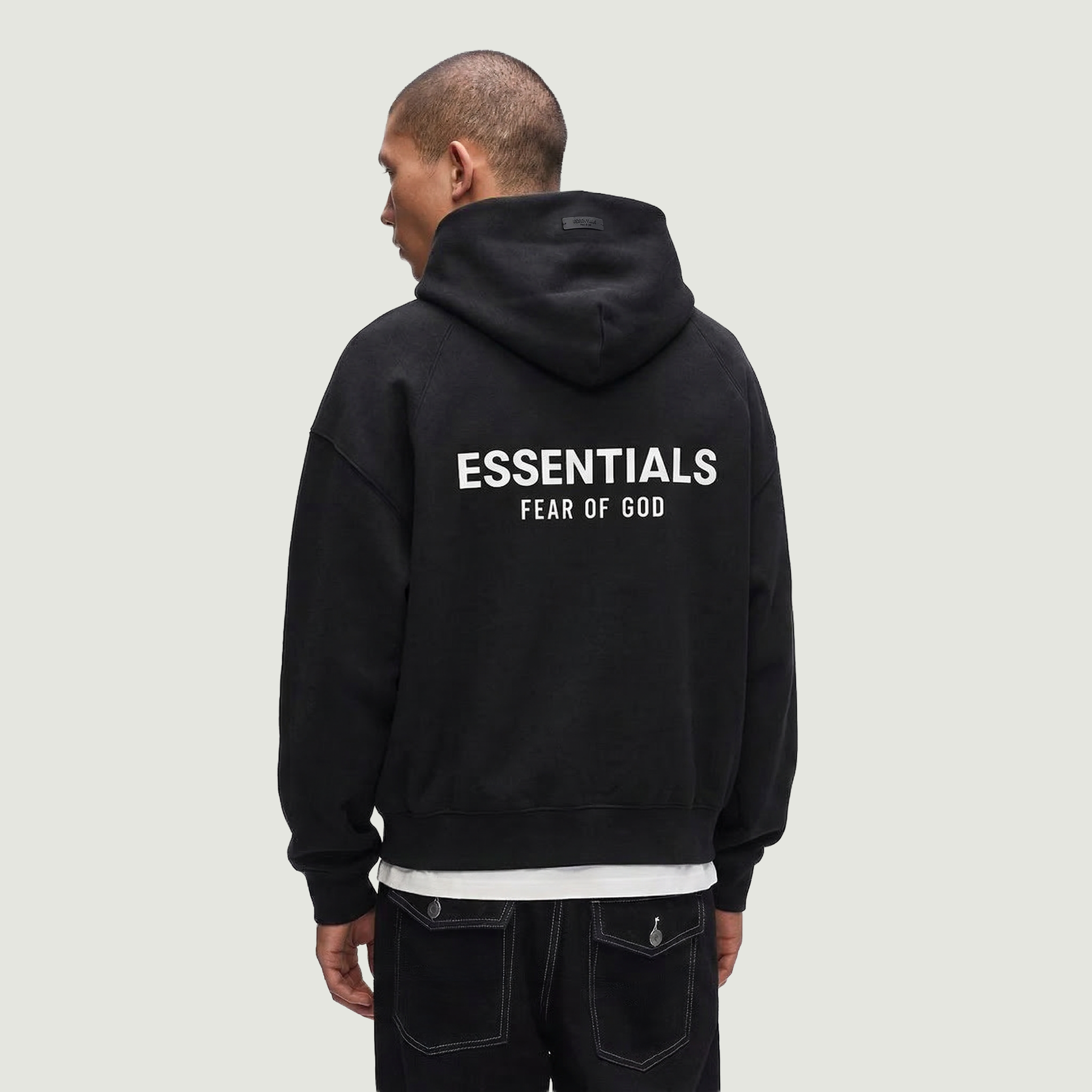 Male wearing Essentials Black Hoodie